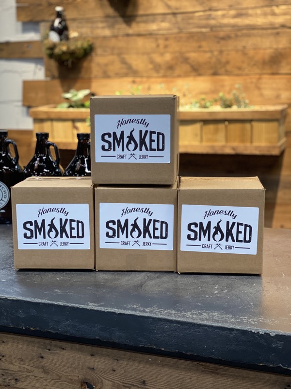 Honestly Smoked kraft jerky boxes stacked in a pyramid in warm side light.